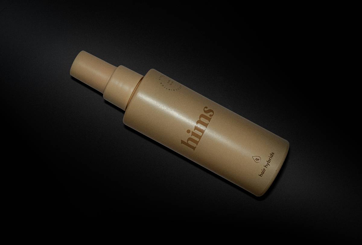 Woman applying hair styling mist evenly on wavy hair from 10 inches away
